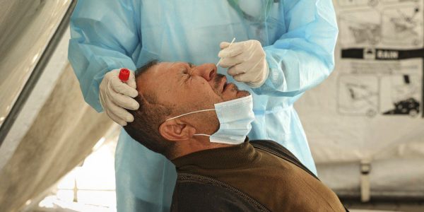 Profissional de saúde faz teste de swab nasal para Covid-19 em um homem em Gaza, Palestina, nesta segunda-feira (27). — Foto: Mahmud Hams / AFP