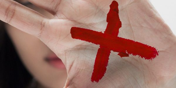 "X" vermelho na palma da mão sinaliza violência