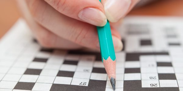 Crossword puzzle close-up.Hand doing crossword